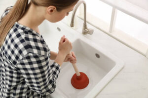 A woman plunging a sink.